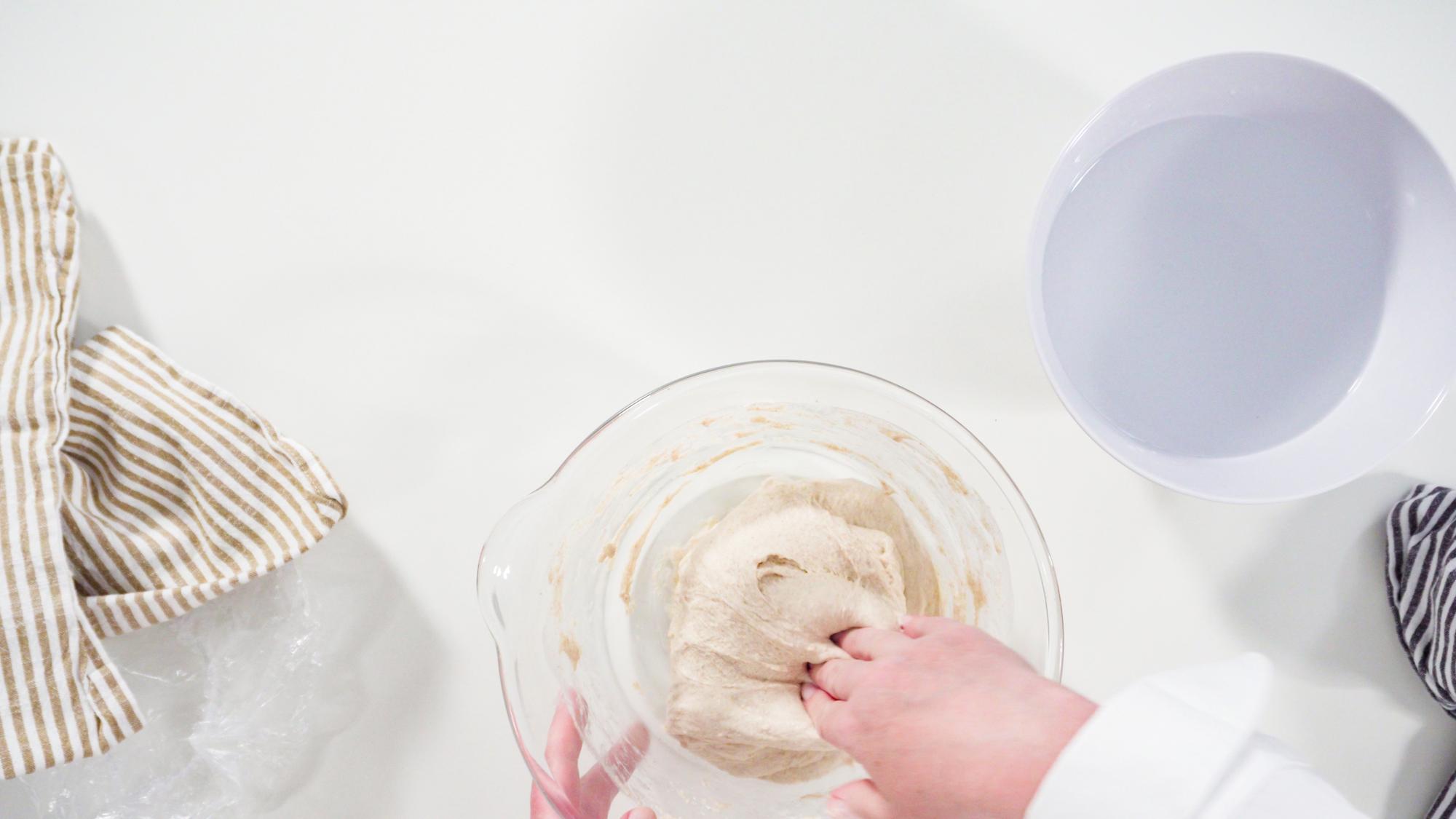 hands kneading dough in natural light